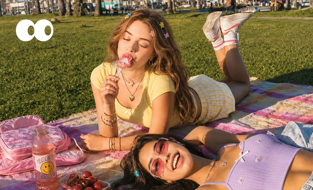 Two friends enjoying a picnic with a Glimboo music lollipop