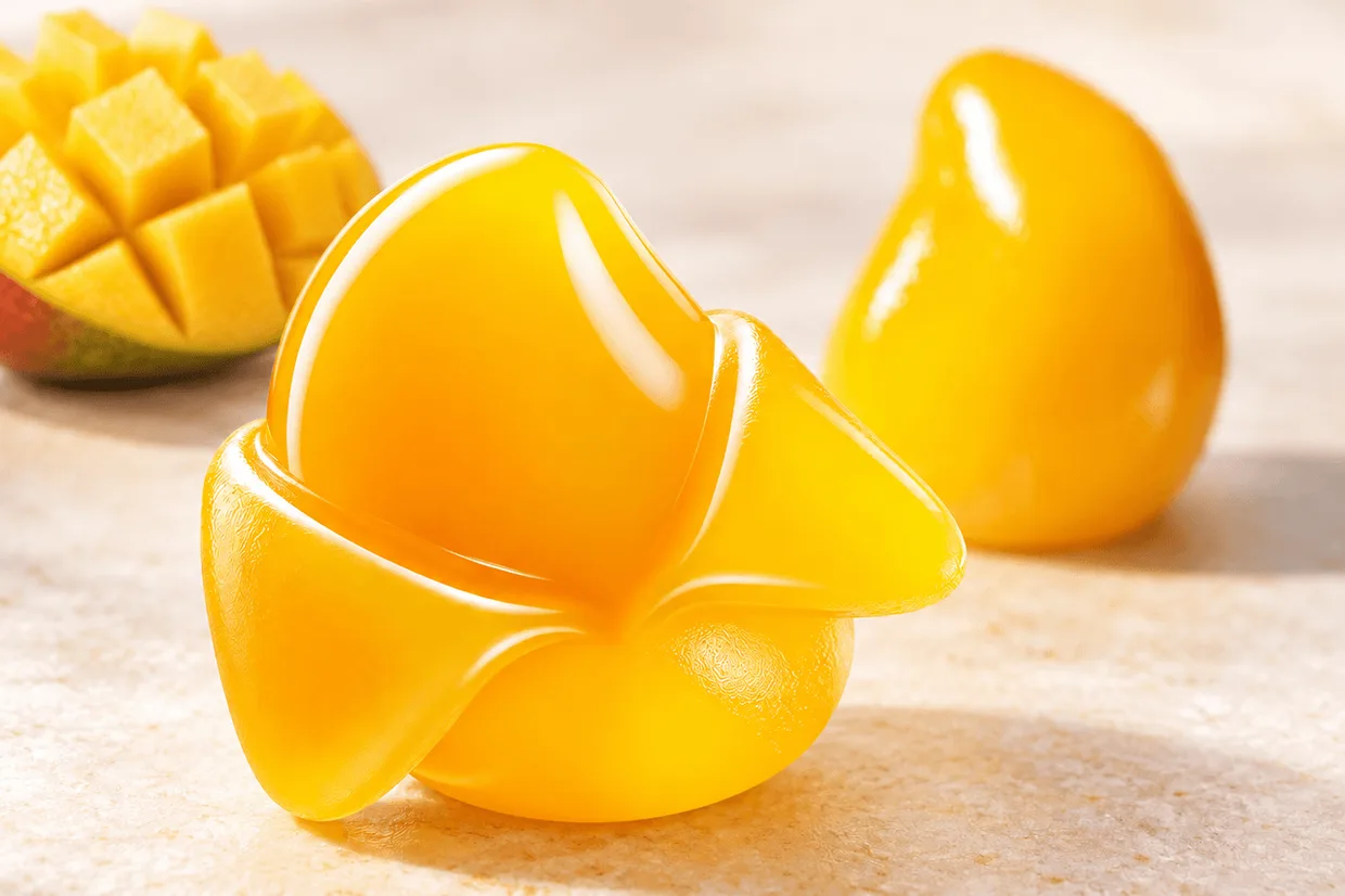 Bright yellow peelable gummies displayed beside sliced mango